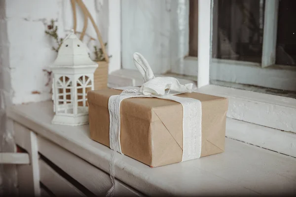 Decoración de Navidad con linterna, caja en papel kraft envuelto, caja de regalo se encuentran en el alféizar de la ventana. Interior minimalista escandinavo . —  Fotos de Stock