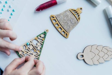 Atölye, kız ahşap Noel süsleri yapıyor. Yaratıcılık için malzeme. Adım adım ustalık dersi. Noel ağacını süslemek için ahşap oyuncaklar. Yaratıcı hobi. El yapımı, şık.
