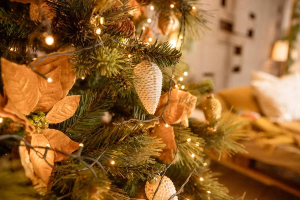 Tannenzweig mit Kugeln und festlichen Lichtern auf dem weihnachtlichen Hintergrund mit funkelndem Weihnachts- und Neujahrsschmuck. Christbaumkugeln am Weihnachtsbaum. flach dof. getöntes Bild. Kopierraum — Stockfoto