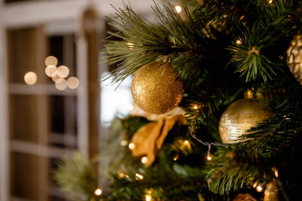 Rama de abeto con bolas y luces festivas en el fondo de Navidad con brillantes.Decoración de Navidad y Año Nuevo. Baubles en el árbol de Navidad. DOF poco profundo. Imagen tonificada. Copiar espacio —  Fotos de Stock