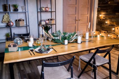 Yanan mumlarla süslü masa dekorları, Noel ve yeni yıl için dekore edilmiş güzel oturma odası dört kişilik şık masa seti ve eski Noel süslemeleri..