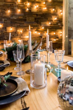 Yanan mumlar ve Noel süslemeleri olan ahşap masa seti. Tatil salonu. Sihirli yeni yıl. Noel ve yeni yıl için dekore edilmiş şenlikli oturma odası. Parlak çelenk.