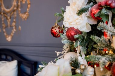 Noel ağacı ve hediyelerle süslenmiş güzel bir holdiay odası. Noel süsü, ışıklar, hediyeler, Noel balosu, koni ve diğer eşyalar, tatil konsepti. Yeni yıl süsü. Beyaz ve kırmızı süsler.