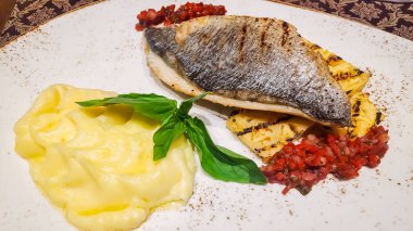 Modern bir tasarım tabağında yakın plan olarak Norveç usulü kızarmış balık filetosu, patates püresi, mantar ve limonata. Kereviz püresi ile garnitür edilmiş fırında balık. Diyet yemek. Sağlıklı yemek.