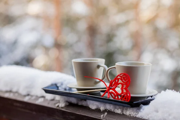 Две чашки с горячим кофе или чаем вместе с сердцами на фоне зимнего леса. украшения ко Дню Святого Валентина или свадьбе. морозный солнечный день в День Святого Валентина. Поздравления с праздником . — стоковое фото