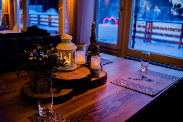 Table de fête de Noël ou du Nouvel An. Image tonifiée.Le concept d'un dîner festif.Décoration de branche festive, bougies et jouets étincelants sur fond de table en bois rustique.Décor de Noël. Hiver — Photo