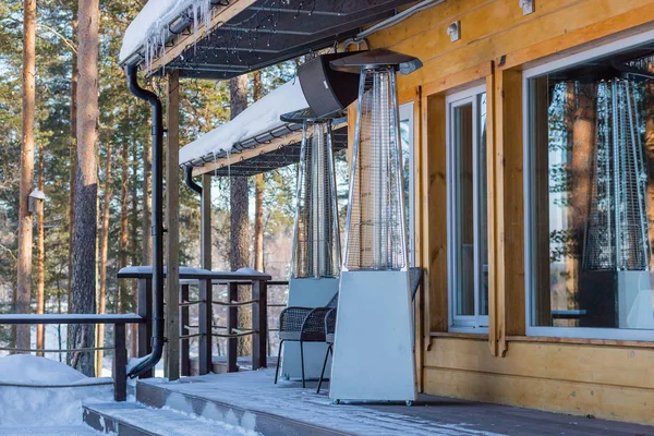 Kışın açık bir kafe masalarının arasına koyulan ısıtma lambası. Veranda için paslanmaz çelik gaz ısıtıcısı. Kafenin açık terasında, evde veya restoranda yüksek ısıtıcı.
