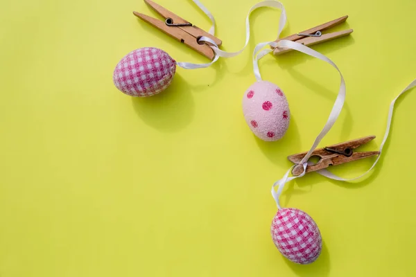 Happy Easter.Поздравительная открытка с крашеными яйцами, висящими на одежде, желтый яркий фон. Копирование пространства — стоковое фото