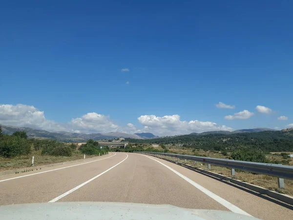 Stock image View of an empty mountains road.right-hand traffic. moving car. Travel with car in europe.beautiful hill landscape through windscreen in sunny day. Driving a car on mountain winding road. Spain,Italy