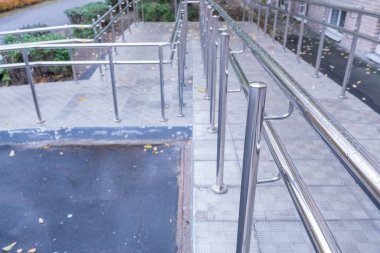Evin girişi tekerlekli sandalye kullanıcıları için özel platformla donatılmış. Otelin kapısındaki metal tekerlekli sandalye rayları. Otoyol giriş çıkışları. Kapalı rampa.