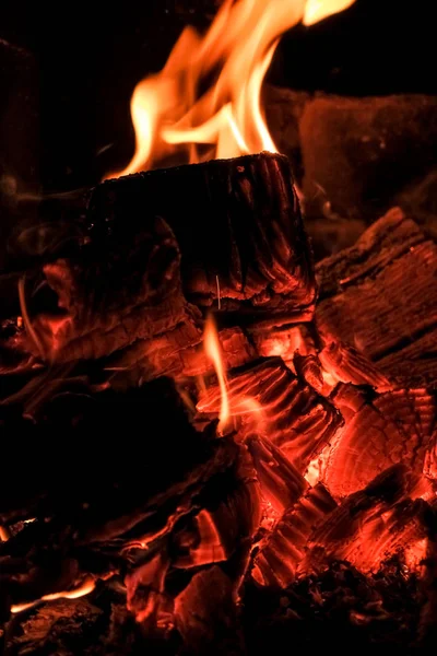 Tre billette ardenti in stufa calda.Fiamma di fuoco che brucia carbone e legna in caminetto.Carbone caldo nel fuoco.Fiamme di un falò nella notte. — Foto Stock