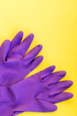 Sarı arka planda izole edilmiş bir çift lastik eldiven. Temizlik için eldiven. Lastik eldivenler. Temizlik için koruyucu eldiven bileşimi. Koruyucu giysi çeşitliliği.