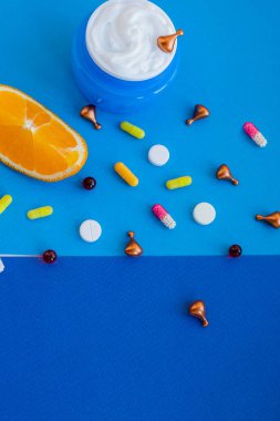 Yağ, hap, vitamin, kapsül, yüz kremi, turunçgil ve portakallı parlak bez. Güzellik kavramını doğal vitamin kozmetik ürünü, cilt bakımı. Güzellik bakımı aroma terapisi