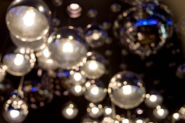 Işınlar ve gümüş lambalar, abajur. Gümüş çemberlerin, dekorun, sanatın soyut arka planı. Etkisiz hale getirilmiş parlak arka plan. Bir sürü gümüş lamba. gece ışığı.