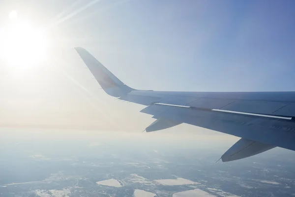 Ala del avión contra el cielo azul con nubes. vista desde eluminador hasta el ala del avión contra el cielo.vuelo, vacaciones, turismo.Vista a través de la ventana de un aeroplano. —  Fotos de Stock