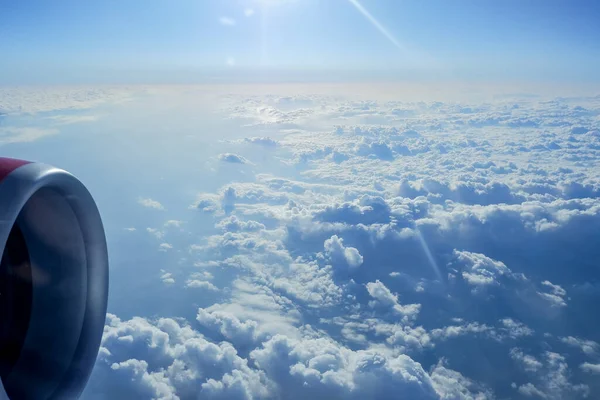 Vue à travers la fenêtre d'un avion pendant un vol au-dessus des nuages pendant la journée.Concept de quarantaine et d'épidémie de coronavirus.Pas de vols - rester à la maison Concept de coronavirus avec avion . — Photo