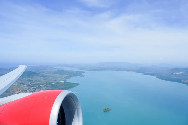 在白天飞越湖泊、岛屿和农村地区时，可以透过飞机的窗户观看。限制民用航班，取消飞机上的航班 — 图库照片