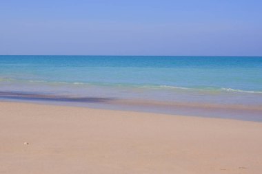 Muhteşem Tropikal plaj, mavi gökyüzünde kum ve güneş. Yaz manzarası. Sahilde beyaz kum ve denizde mavi su olan güzel deniz manzarası. Seyahat kavramı. Doğa geçmişi. Yaz tatili kavramı.