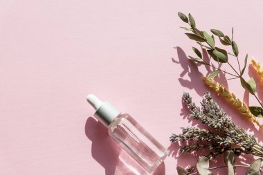 Lavanta ve portakallı doğal kozmetik ürünleri, pembe arka plan manzaralı ev yapımı spa 'lar için limon. Lavanta masaj yağı şişesi - güzellik tedavisi. Boşluğu kopyala