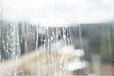 Cam yıkama ya da soyut arka plan için pencereye sabun sıkmak. Işıkların altındaki pencereye cam temizleyici sıkmak. Cam pencereyi temizlemek..