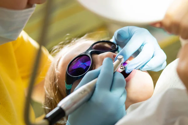 close-up medical dentist procedure of teeth polishing.Child girl having professional dental cleaning or polishing in dentist office. Toddler girl visiting the dentist for cleaning and checkup