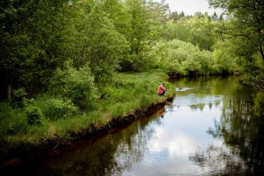 Spor balıkçısı yırtıcı balık avlıyor. Gün doğarken nehirde açık havada balık tutmak. Avcılık ve hobi sporu.