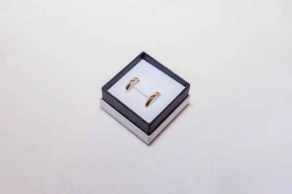 Anillos de boda dorados en caja. Anillo de oro para joyas aislado sobre fondo blanco.Precioso anillo de compromiso brillante en rica caja de terciopelo negro. Día de San Valentín gesto de propuesta presente. Copiar espacio . — Foto de Stock