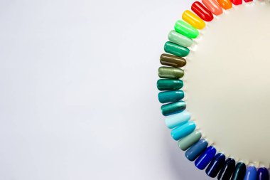 Beyaz arka planda izole edilmiş renk ojeli palet. Farklı parlak renkler. Renkli tırnak törpüsü manikür örnekleri reklamı. Çivi sanatı paletinin en üst görüntüsü. Boşluğu kopyala