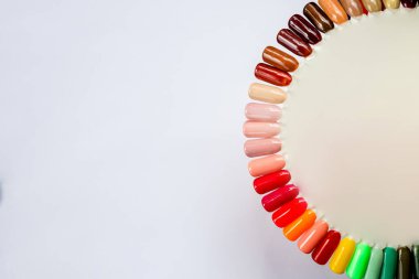 Beyaz arka planda izole edilmiş renk ojeli palet. Farklı parlak renkler. Renkli tırnak törpüsü manikür örnekleri reklamı. Çivi sanatı paletinin en üst görüntüsü. Boşluğu kopyala