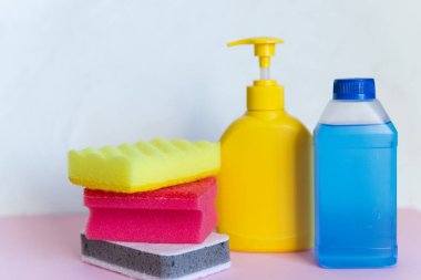 Beyaz arka planda ev kimyasalları. Profesyonel temizlik ürünleri, bahar temizliği. Ev deterjanları için sarı ve mavi plastik kaplar, ev kimyası. Temizlik malzemeleri.