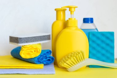 Beyaz arka planda ev kimyasalları. Profesyonel temizlik ürünleri, bahar temizliği. Ev deterjanları için sarı ve mavi plastik kaplar, ev kimyası. Temizlik malzemeleri.