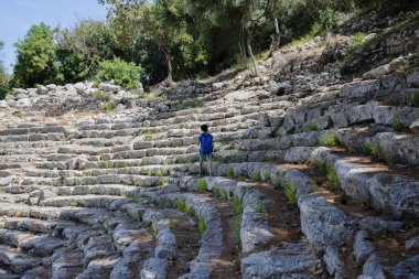 Turist çocuğun antik amfitiyatro strairs üzerinde aşamalarında