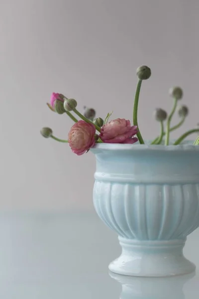 Розовые цветки в бледно-зеленой керамической вазе — стоковое фото
