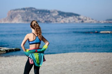Alanya'da spor giyim sahilde duran genç kadın