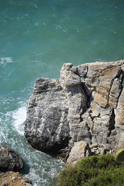 Roca vertical en el mar bañada por las olas —  Fotos de Stock
