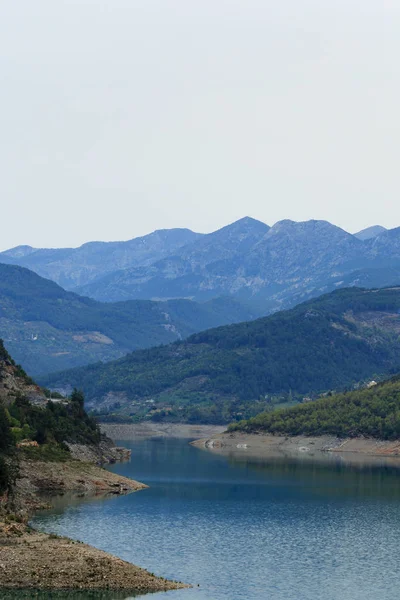 Βουνά που καλύπτονται από πευκοδάση, κατεβαίνοντας στη λίμνη — Φωτογραφία Αρχείου