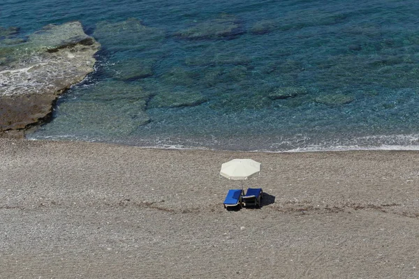 Красивий пляж з кришталево чистою водою і блакитними лежаками — стокове фото