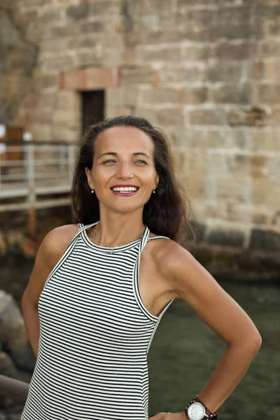 Siyah ve beyaz şerit içinde gülümseyen esmer kadın