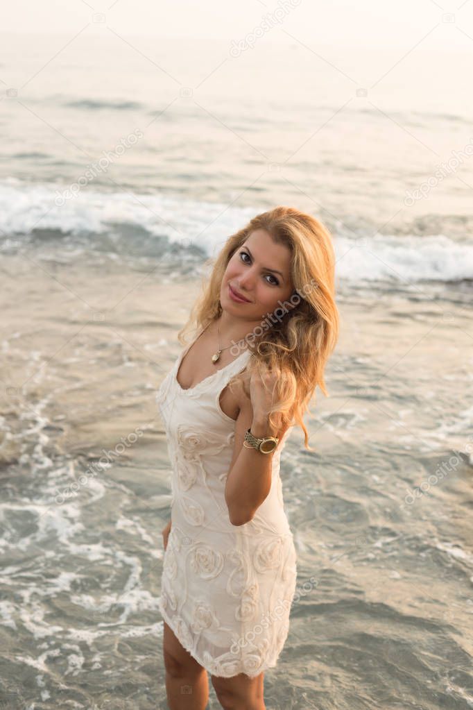 Beautiful blonde woman by seaside