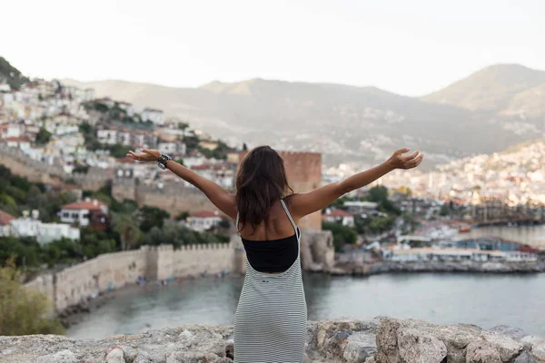 Mujer viajera con los brazos extendidos mirando a la bahía de Alanya —  Fotos de Stock