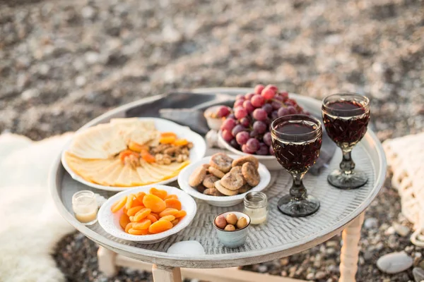 Outdoors picnic with wine, cheese, grapes and dried fruits — Stock Photo, Image
