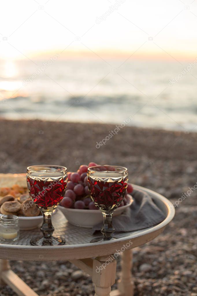 romantic dinner with wine and grapes by seaside