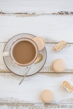 Topview süt ve pembe macaroons ile bir fincan kahve vurdu. Kopyalama alanı.