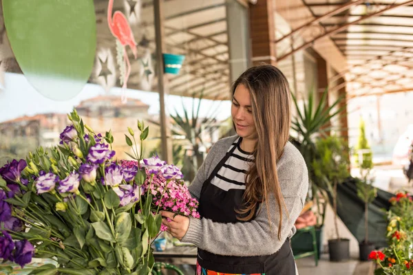 Florista feminina trabalhando em uma loja de flores — Fotografia de Stock