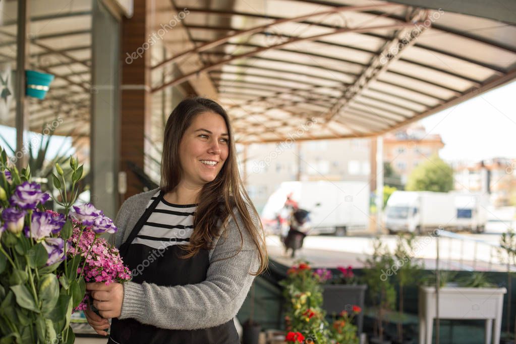 smiling female florist in a flower shop 