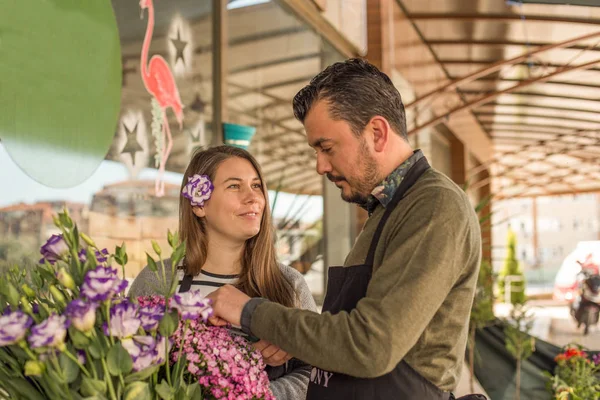 Casal de floristas trabalhando em uma loja de flores — Fotografia de Stock
