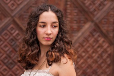 Güzel dalgalı saçlı genç bir romantik kız baş ve omuzlar portresi.