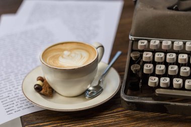 cappucino vintage daktilo ile ahşap masa üstü ve yazdırılan metin sayfaları bir fincan