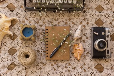 Bahar ya da yaz serbest, iş veya kavramı yazma. Dantel masa örtüsü vintage film kamerası, kabukları ve mum üzerinde siyah kalem ile not etmek. Üst görünüm vurdu. Yatay kompozisyon.