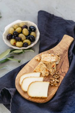 küçük peynir kurulu ile iki farklı tür-in siyah keten ve deniz kabuğu zeytin peynir seramik tabak şeklinde. Dikey kompozisyon.